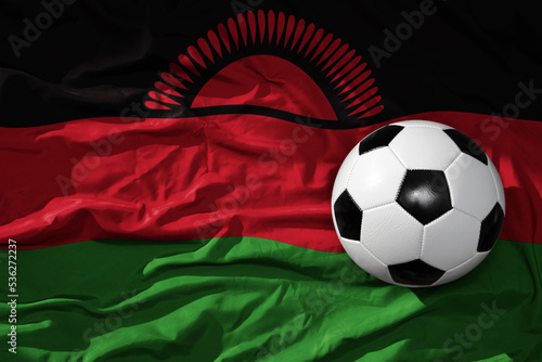 vintage football ball on the waveing national flag of malawi background. 3D illustration