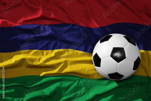 vintage football ball on the waveing national flag of mauritius background. 3D illustration
