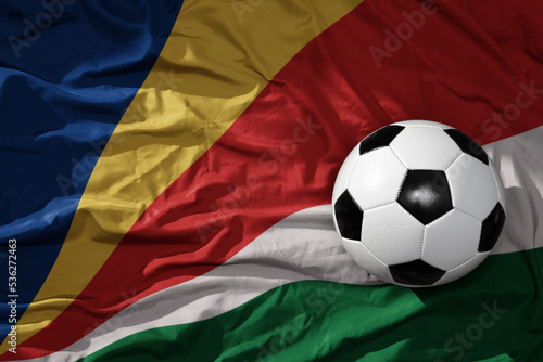vintage football ball on the waveing national flag of seychelles background. 3D illustration