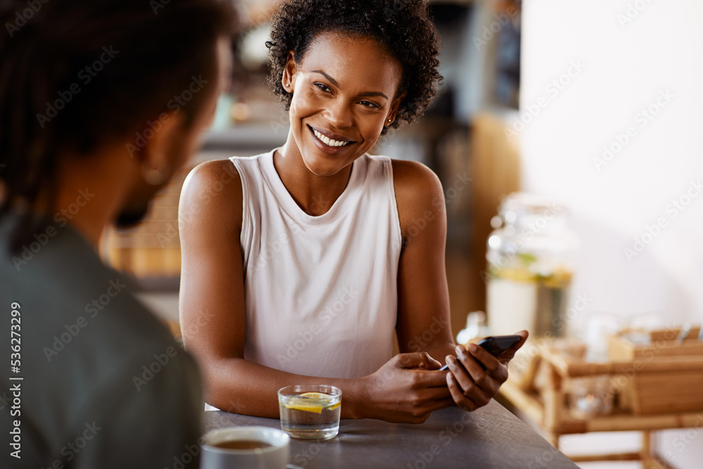 Smiling woman sitting at a cafe table with her boyfriend Smiling woman sitting at a cafe table with her boyfriend
