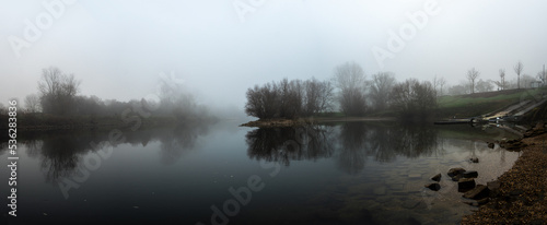 Fototapeta Naklejka Na Ścianę i Meble -  sehr ruhige dramatische Fluss mit Bäumen Silhouette Panorama