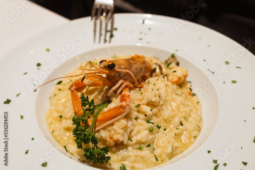 Eating traditional Italian seafood risotto with king prawns and scampi lobster