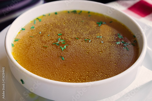 Rich beef bouillon with homemade pasta and herbs served in the restaurant of Ljubljana, Slovenia