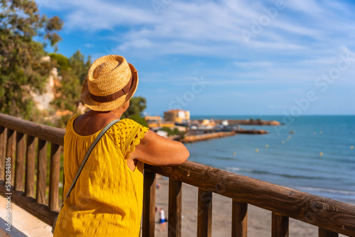 Elderly lady looking at the sea beach of La Caleta in Cabo Roig. Alicante. senior travel photo