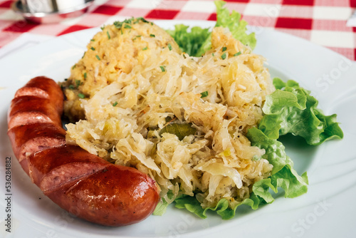 Traditional dish in Slovenia - kranjska klobasa (pork sausage) with mashed pea puree and stewed cabbage photo