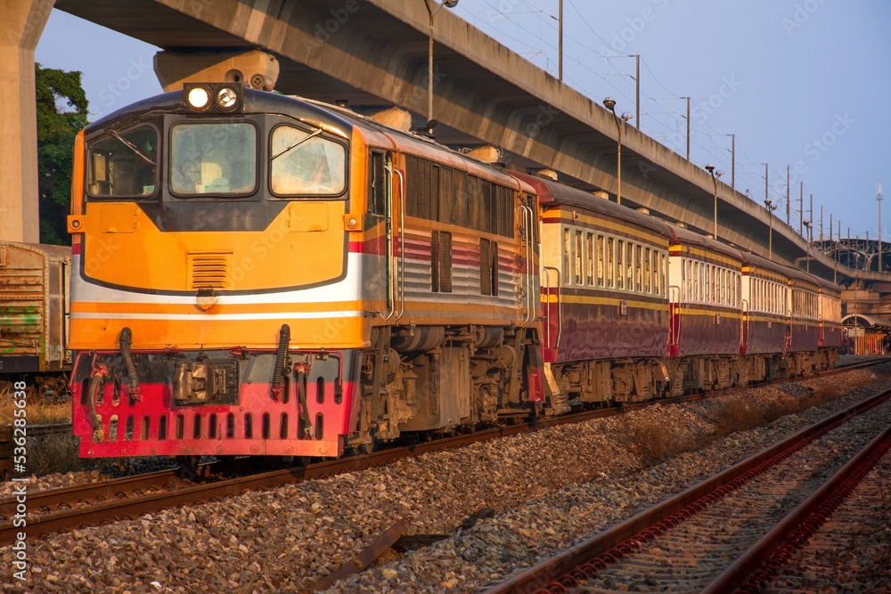 Fototapeta premium Passenger train by diesel locomotive at the railway station.