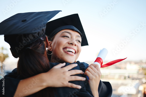 Graduation, education and hug with woman student friends hugging on university campus in celebration of success or qualification. College, graduate and scholarship with a female and friend embracing photo
