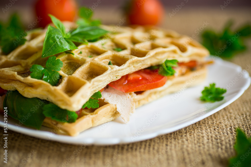 Sandwich of two egg omelettes with bacon and tomatoes inside