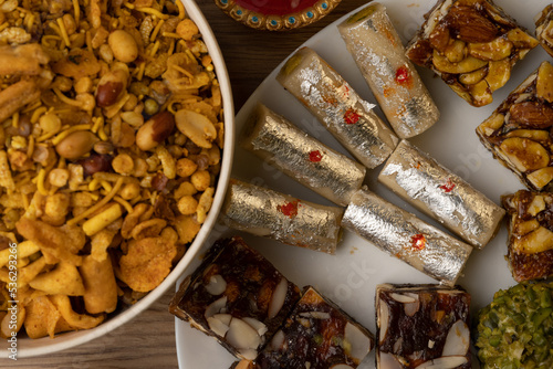 Mix indian sweets like kaju roll dryfruits barfi mango peda served in a plate photo