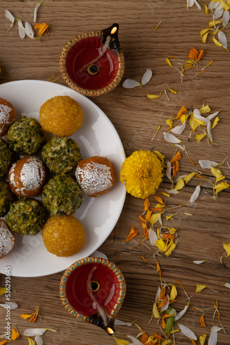 plate full of assorted laddoos like motichur laddoo, bundi ladu and pistchio laddu with farsan or namkin photo