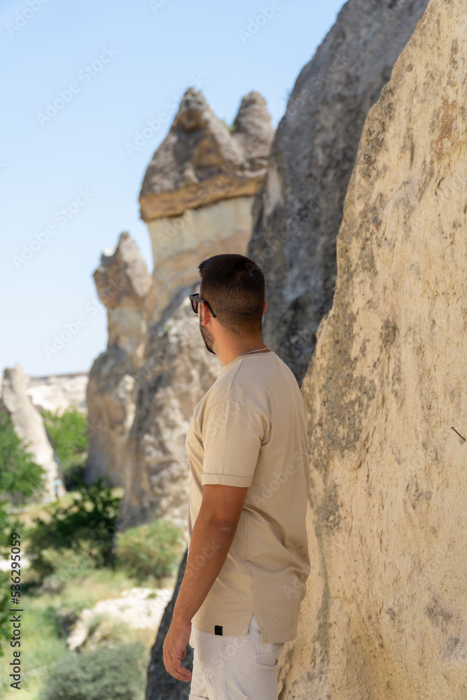 Unrecognizable tourist looking at the pasabag valley with typical rock formations of the cappadocia area in turkey. Unrecognizable tourist looking at the pasabag valley with typical rock formations of the cappadocia area in turkey.