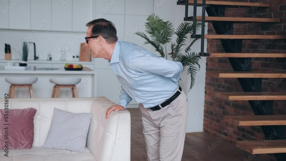 Elderly man standing with pain in back Elderly man standing with pain in back