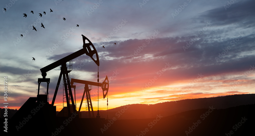 Fototapeta premium The change in oil prices caused by the war. Oil prices are rising because of the global crisis. Oil drilling derricks at desert oilfield. Crude oil production from the ground. Petroleum production.