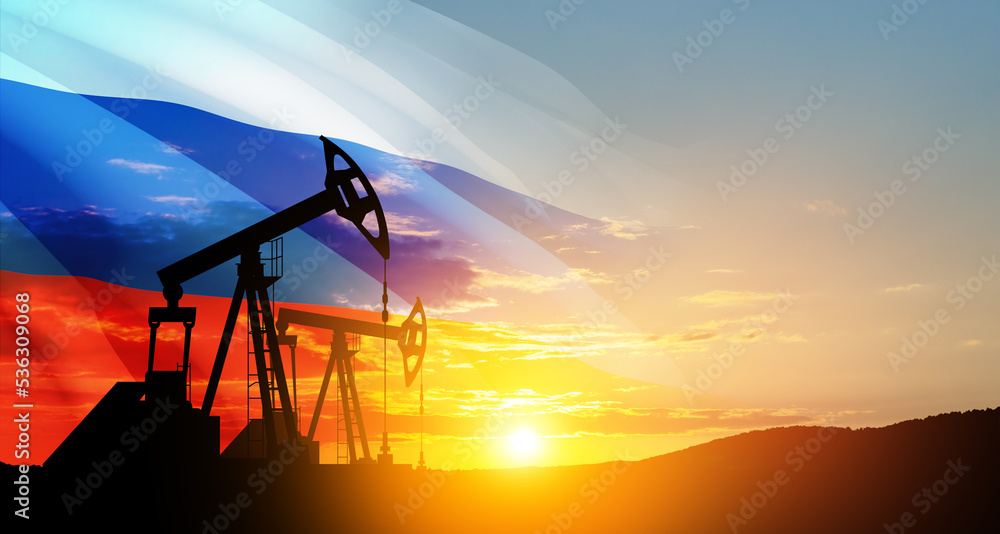 The change in oil prices caused by the war. Oil prices are rising because of the global crisis. Oil drilling derricks at desert oilfield with Russia flag. Crude oil production from the ground.