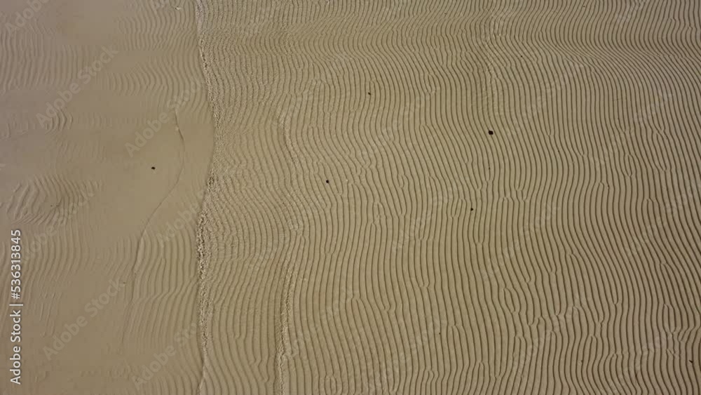 sandy beach shot by drone at a low altitude above, sea waves sandy beach shot by drone at a low altitude above, sea waves