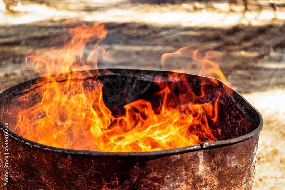 Burning fire in a barrel close-up. Bright flame. Open flame heating. Problems with heating and gas. Burning fire in a barrel close-up. Bright flame. Open flame heating. Problems with heating and gas.