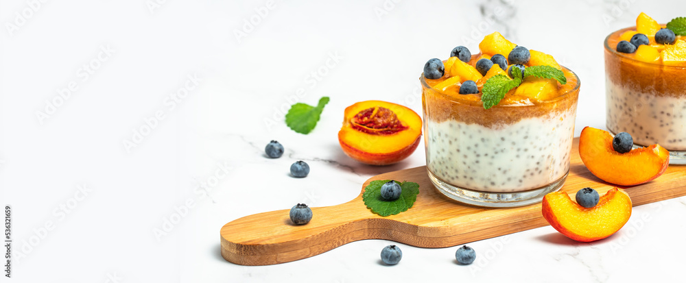 peaches blueberry chia yogurt on a light background. Homemade dessert with fruits. Long banner format