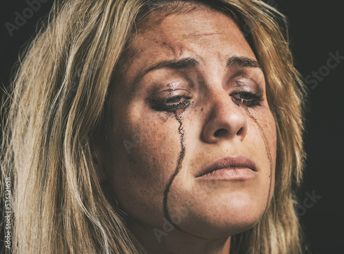 Foto Sad, depression and woman crying with makeup smudge on face from tears with studio wall closeup
