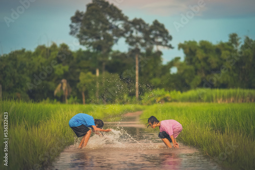 Children playing water of flooding in countryside