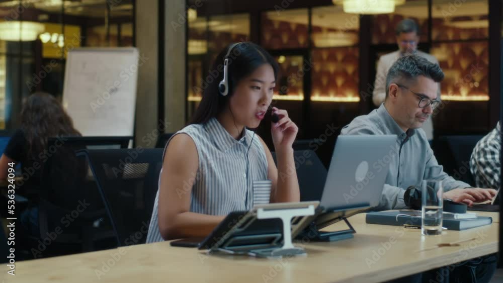 custom made wallpaper toronto digitalAsian female operator in headset in call center talking with client, using laptop and digital tablet. Work in call center of marketing company. Multi-ethnic office workers team