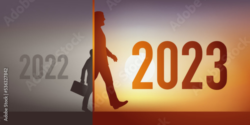 Concept de croissance et de développement pour une entreprise en 2023, avec comme symbole, un homme qui change d’année en ayant doublé de taille.
