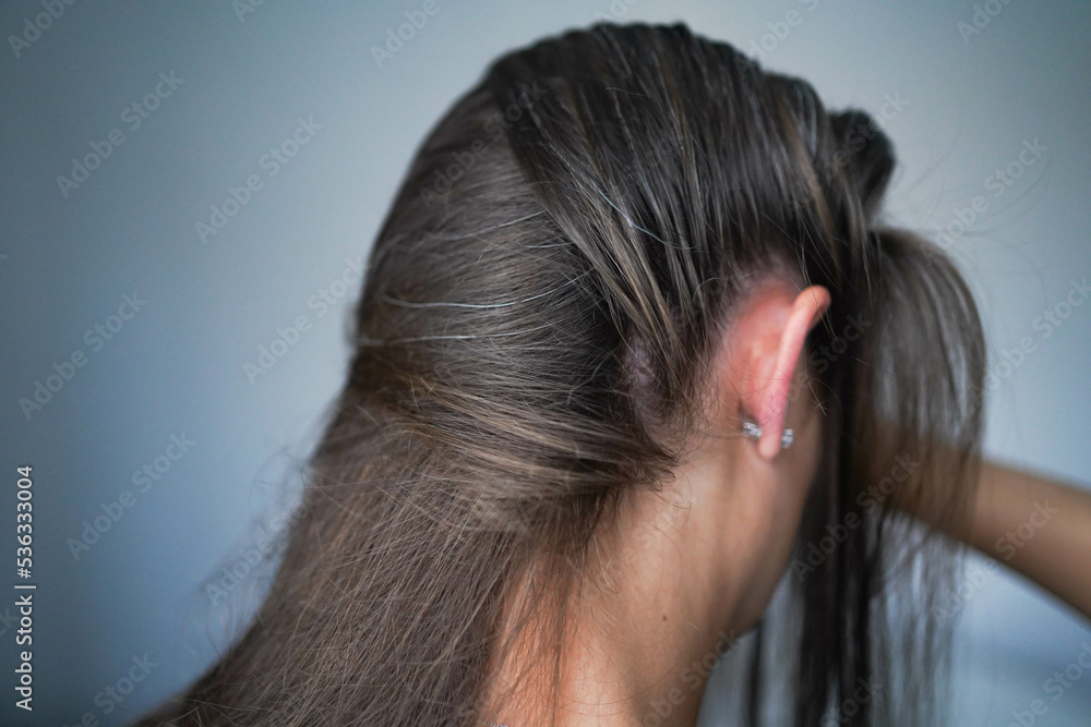 Gray hairs on the head of a young girl. Long gray hair. The initial stage of gray hair. The problem of gray hair in women. Gray hairs on the head of a young girl. Long gray hair. The initial stage of gray hair. The problem of gray hair in women.