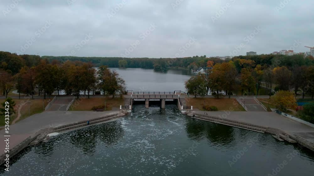 Flight over a river with waterfalls and a park in early autumn on a cloudy day. Flight over a river with waterfalls and a park in early autumn on a cloudy day.