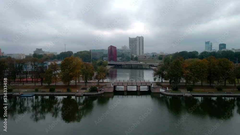 Flight over a river with waterfalls and a park in early autumn on a cloudy day. Flight over a river with waterfalls and a park in early autumn on a cloudy day.