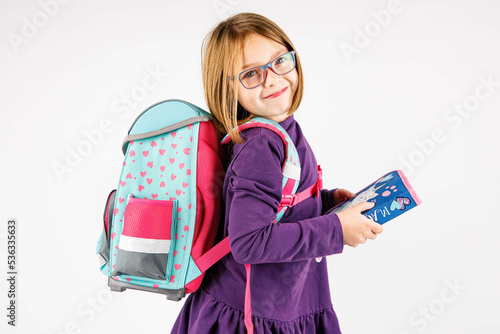 Dziecko w szkole, z plecakiem i piórnikiem w ręce, pilny uczeń gotowy do nauki szkolnej photo