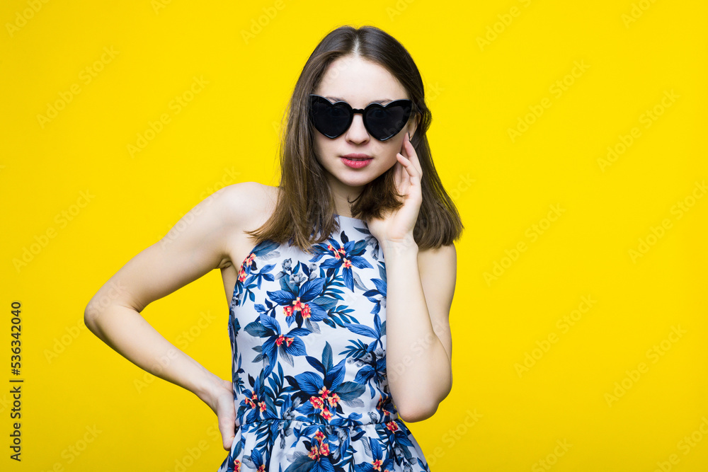 A young woman in a dress and sunglasses.Young woman fashion portrait. A young woman in a dress and sunglasses.Young woman fashion portrait.