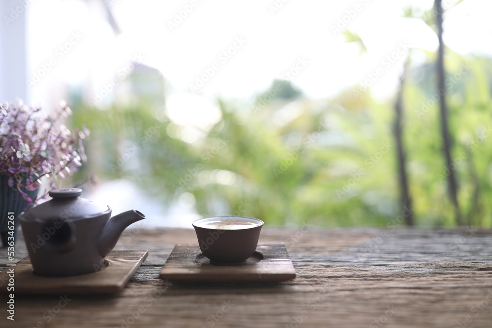 Earthenware tea pot and cup on wooden table outdoor chill relaxing view Earthenware tea pot and cup on wooden table outdoor chill relaxing view