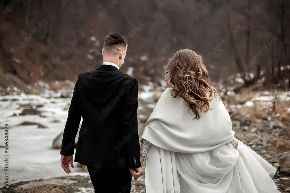 Bride and groom running near the river Bride and groom running near the river