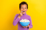 Photo of excited funky person arms hold eat popcorn plate have good mood isolated on yellow color background