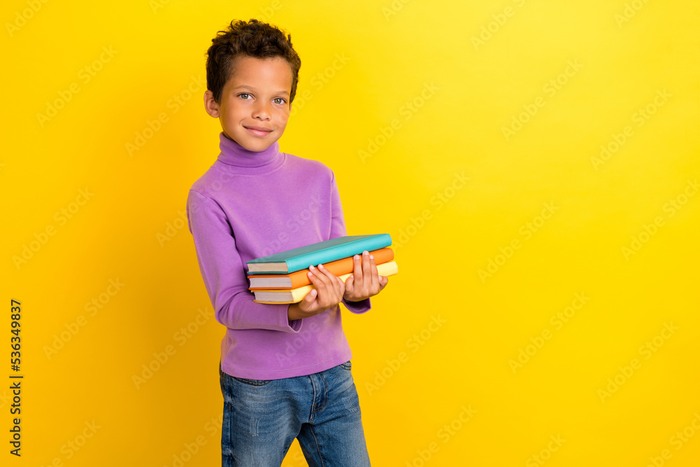 Photo of intelligent schoolkid arms hold pile stack book homework isolated on yellow color background Photo of intelligent schoolkid arms hold pile stack book homework isolated on yellow color background