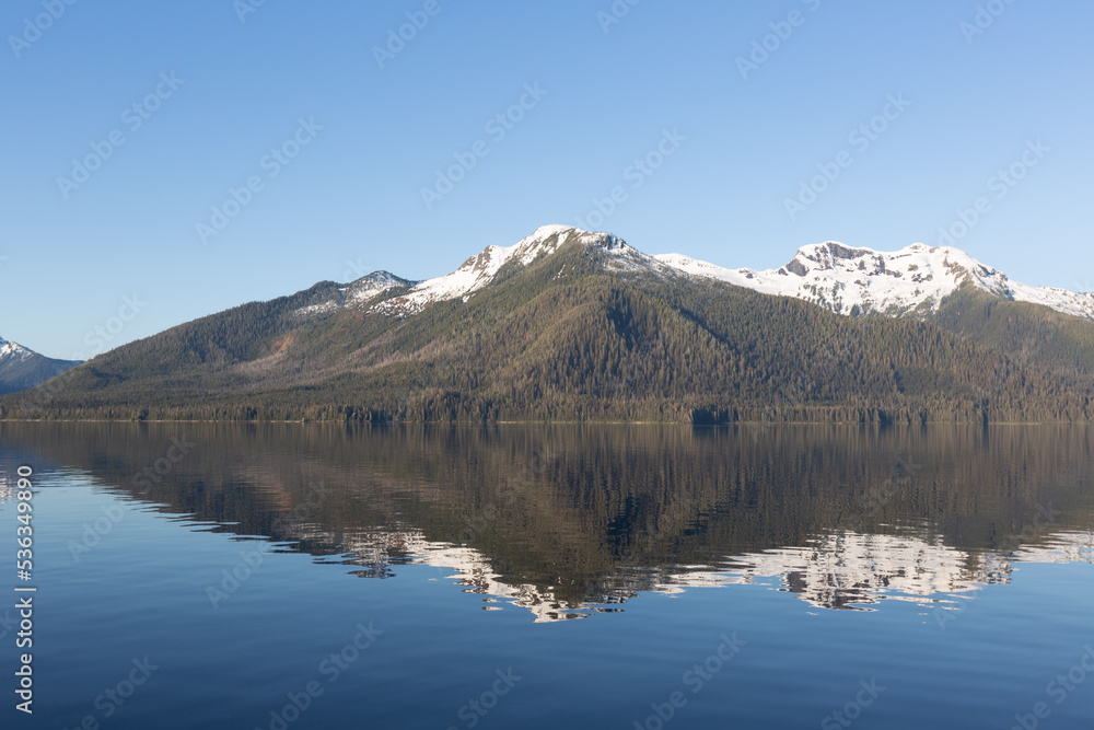Sunrise on mountains and mirror like reflection in sea water