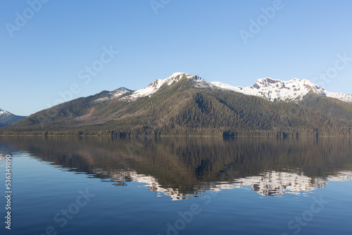 Sunrise on mountains and mirror like reflection in sea water