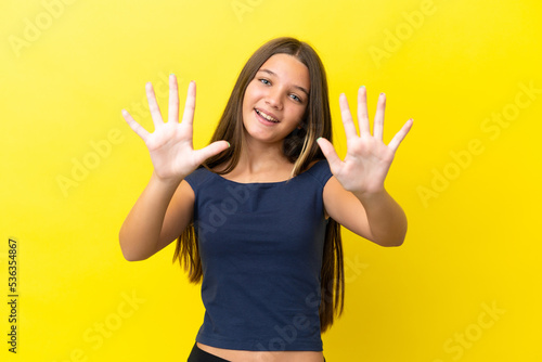 Little caucasian girl isolated on yellow background counting ten with fingers