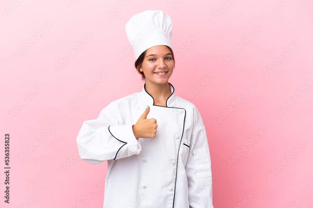 Little caucasian chef girl isolated on pink background giving a thumbs up gesture Little caucasian chef girl isolated on pink background giving a thumbs up gesture