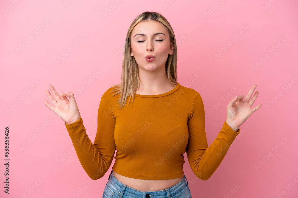 Young caucasian woman isolated on pink background in zen pose Young caucasian woman isolated on pink background in zen pose