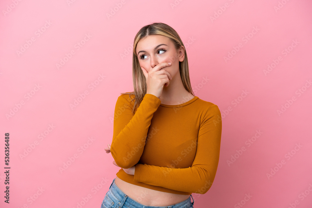 Young caucasian woman isolated on pink background having doubts and with confuse face expression Young caucasian woman isolated on pink background having doubts and with confuse face expression