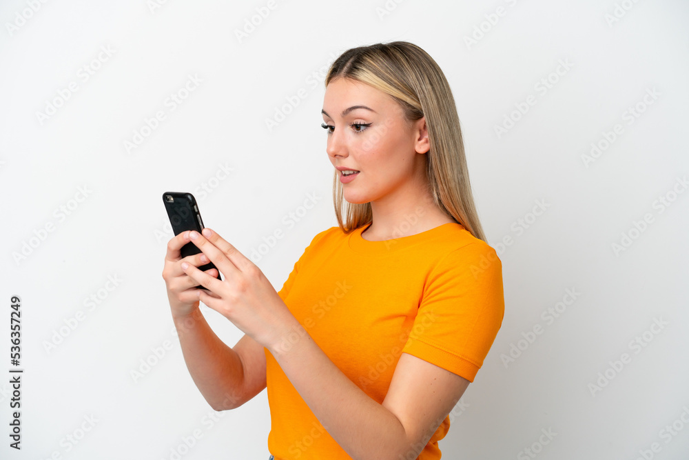 Young caucasian woman isolated on white background sending a message or email with the mobile