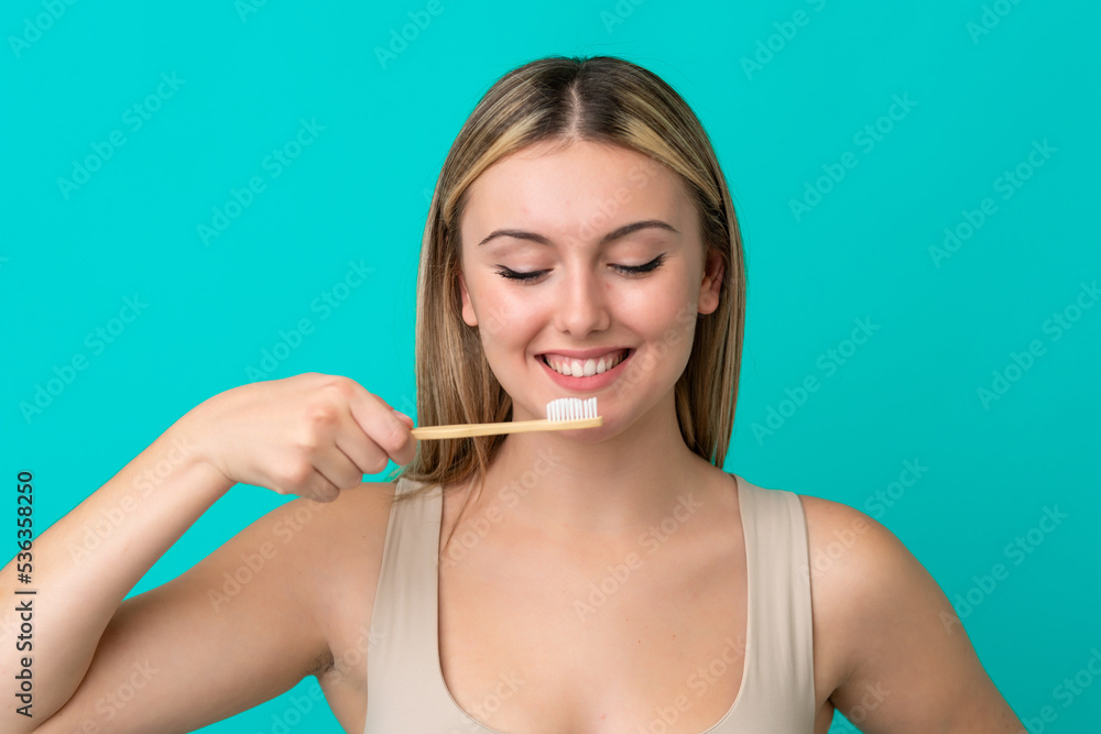 Young caucasian woman isolated on blue background with a toothbrush and happy expression Young caucasian woman isolated on blue background with a toothbrush and happy expression