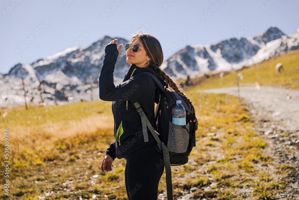 Hiker girl climbing a mountain path looking for snow
