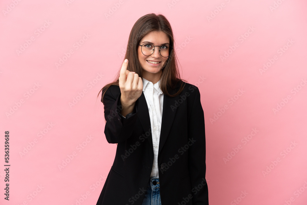 Young Business caucasian woman isolated on pink background doing coming gesture
