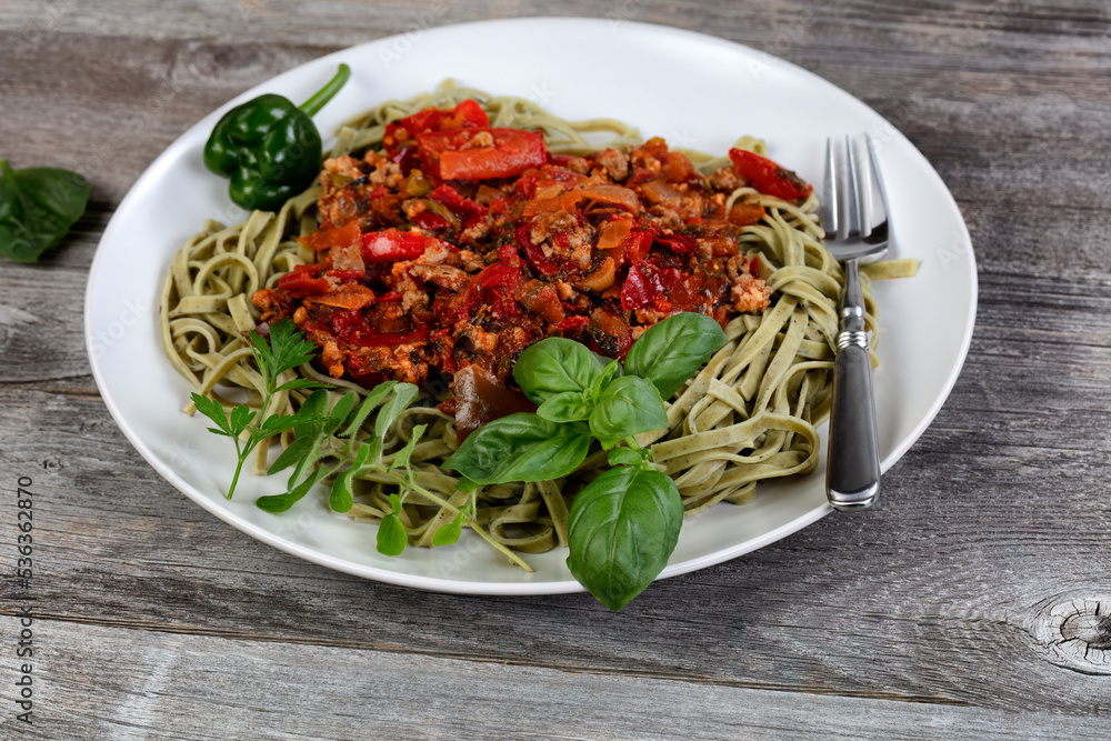 Traditional Italian dinner spaghetti dish on rustic wooden table Traditional Italian dinner spaghetti dish on rustic wooden table