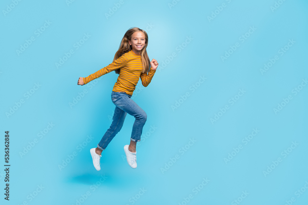 Full length photo of excited sportive person jumping rush fast isolated on blue color background Full length photo of excited sportive person jumping rush fast isolated on blue color background