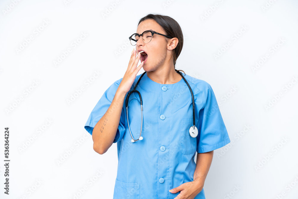 Young nurse woman isolated on white background yawning and covering wide open mouth with hand Young nurse woman isolated on white background yawning and covering wide open mouth with hand
