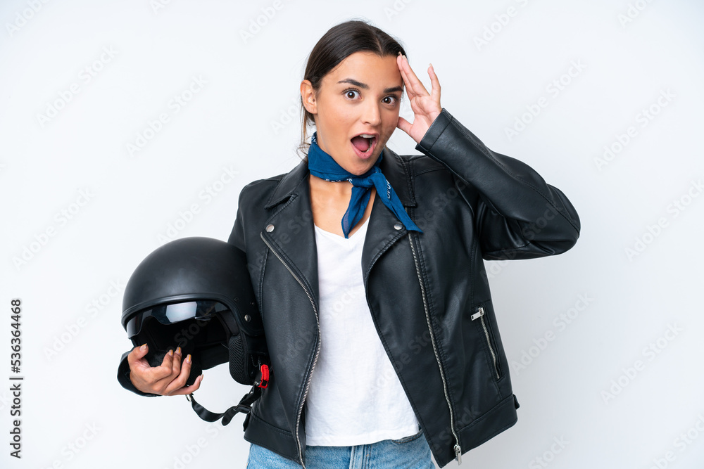 Young caucasian woman with a motorcycle helmet isolated on blue background with surprise expression Young caucasian woman with a motorcycle helmet isolated on blue background with surprise expression