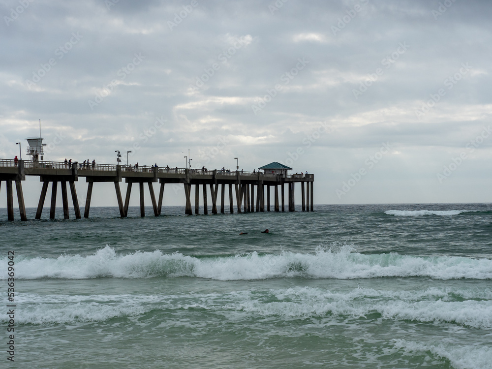 Ocean pier with cloudy sky