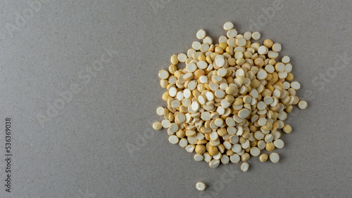 pile of roasted or fried bengal gram on a gray textured background, also known as chenna dal or pori or pottu kadalai,healthy indian crispy snack taken from above with copy space photo